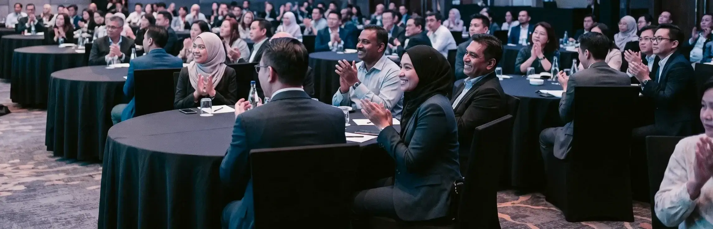 Delegates applauding at a leadership conference plenary session